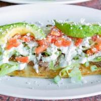 Huarache · A handmade, oval shaped Corn Tortilla smothered with Refried Beans and topped with Meat, Oni...