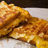 British Cheese Toastie · Decadent layers of melty gruyere, jack and cheddar cheeses, topped with sweet tamarind bbq c...