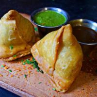Samosas · 2 crispy triangle pastries stuffed with spiced potato and peas. Served with sweet tamarind b...