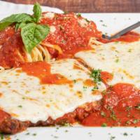 Veal Parmigiana · Battered in eggs, topped with tomato sauce and mozzarella cheese. Served with a side of spag...