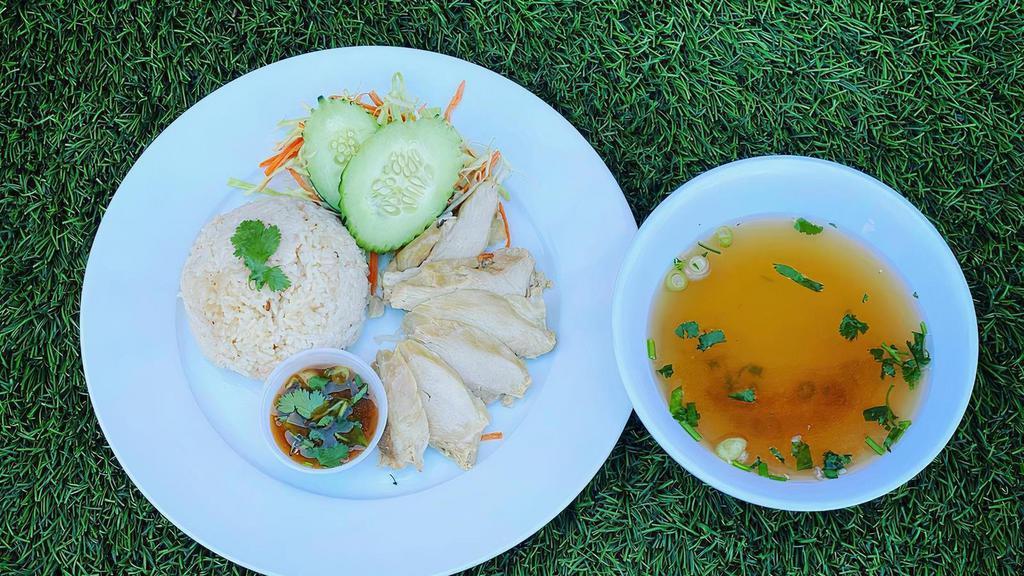 Hainan Chicken Rice · Steamed chicken over jasmine rice topped with cilantro and ginger sauce