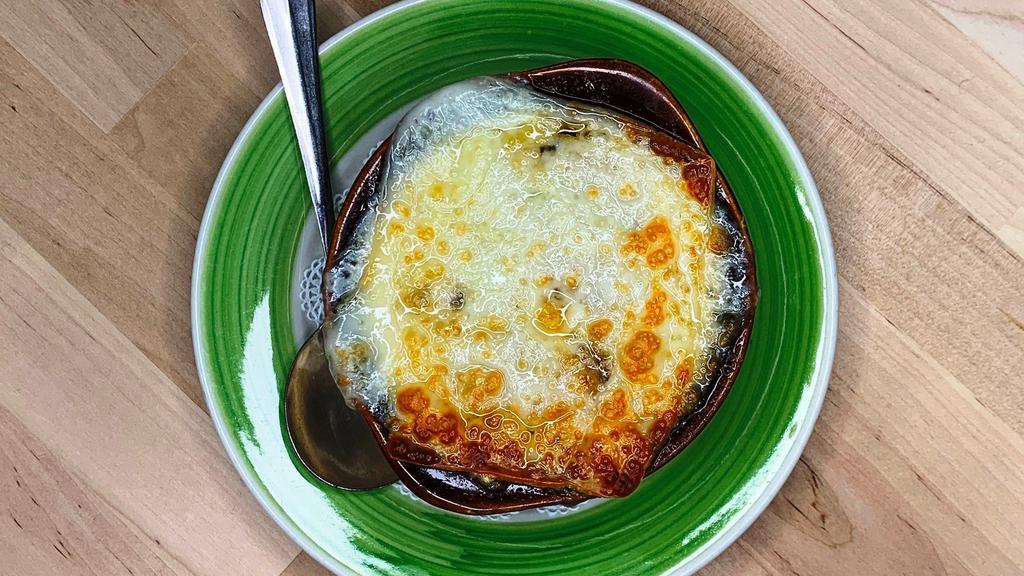 French Onion Soup · Topped with a crouton; melted mozzarella & Swiss.