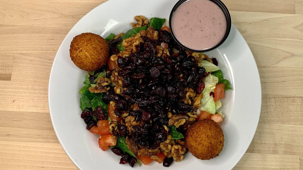 Goat Cheese Salad · Panko-crusted goat cheese, walnuts, tomatoes, cranberries & mixed greens; served with a side of blueberry pomegranate vinaigrette.