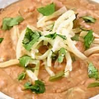 Spicy Bean Dip · Served with house-made tortilla chips, cucumber, carrots, celery, and topped with pico and q...