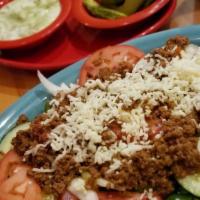 Taco Salad · Crisp flour tortilla filled with ground beef or chicken, beans, lettuce, tomatoes, grated ch...