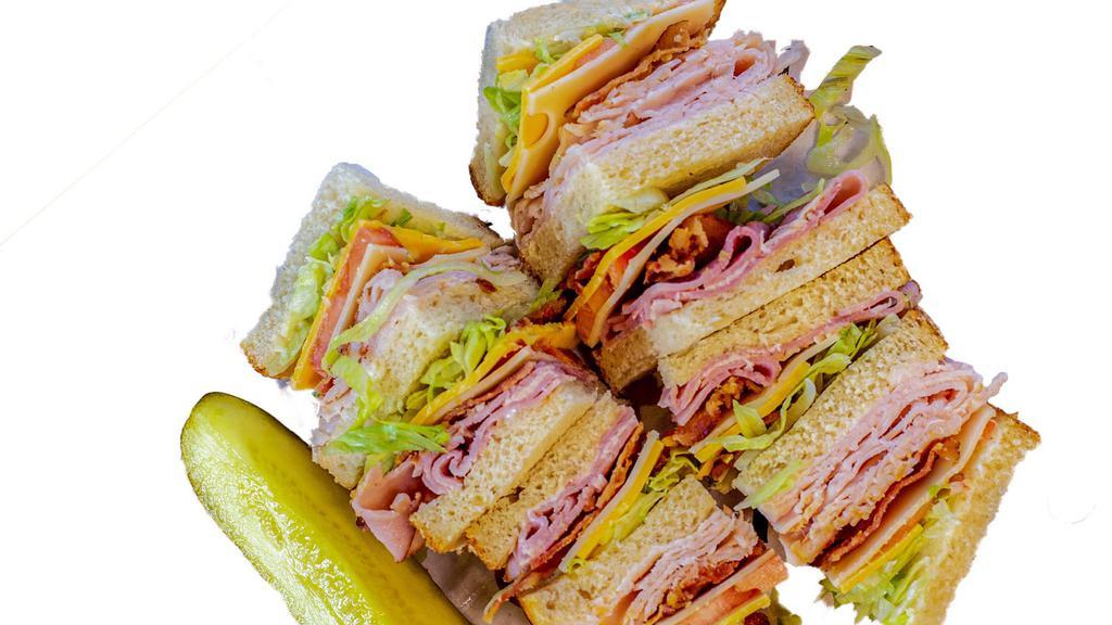 The Club · Boring but beautiful. Turkey, ham, Swiss and American layered on white toast with lettuce, tomato, smoked bacon, and mayo.
