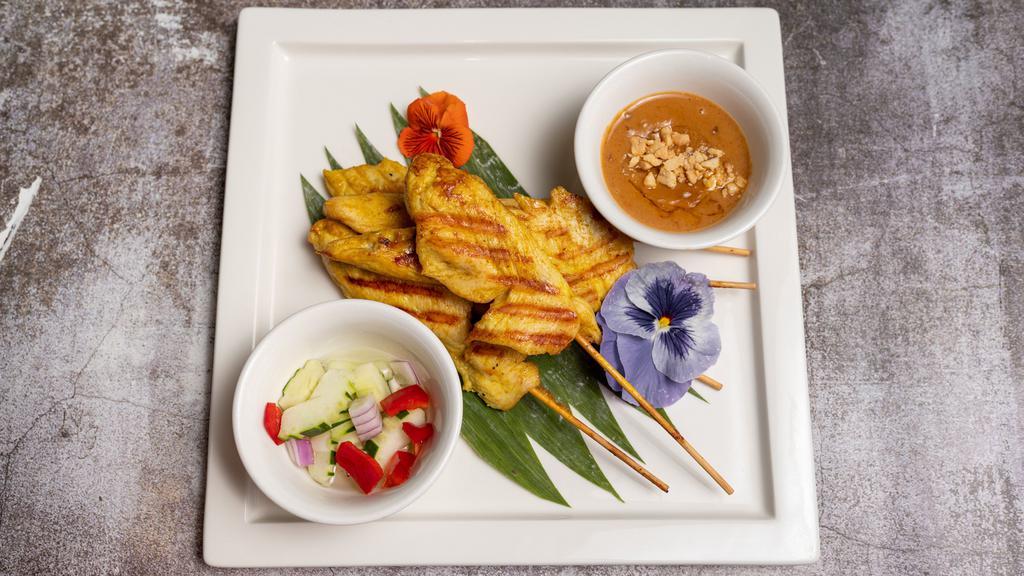 Satay Chicken · Grilled marinated chicken with herbs, served with warm peanut sauce and cucumber salad.