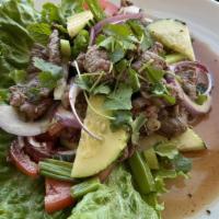 Yum Neau (Steak Salad) · Sliced new York beef steak mixed with lime juice, cucumbers, chili, red onions, tomatoes and...