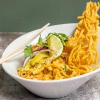 Khao Soi Gai · Northern style curry noodle, egg noodle in delicious curry sauce with chicken drumstick, pic...