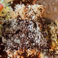 Enchiladas Poblanas O Verdes · Corn tortillas filled with chicken, sour cream, and white cheese, topped with mole sauce and...