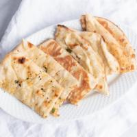 Garlic Naan · Vegetarian, traditional Indian style leavened bread baked in a traditional tandoor oven with...