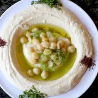 Hummus · Grounded chickpeas with tahini (sesame paste) lemon and olive, comes with pita bread.