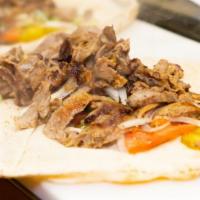 Beef Shawarma Wrap · Beef shawarma with pickles, onion, tomatoes and tahini sauce. Served. On Lebanon bread.