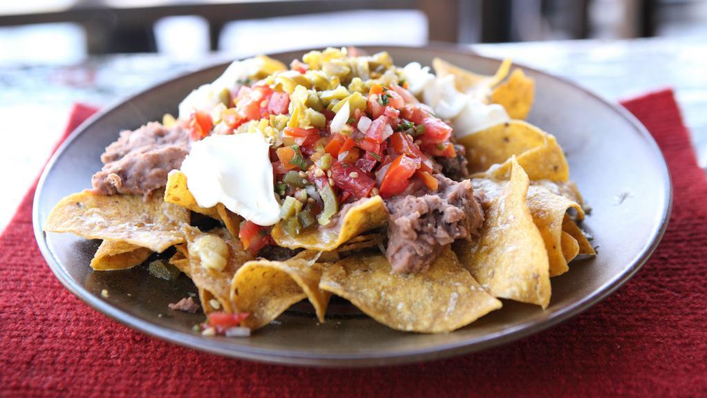 Nacho Ground Beef · The nachos come with cheese, beans, lettuce, pico de gallo, salsa, shredded cheese, sour cream, and jalapeños.