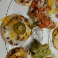 Nachos Platter  · round chips, topped with refried beans, cheese, served with side of jalapeños, sour cream, g...