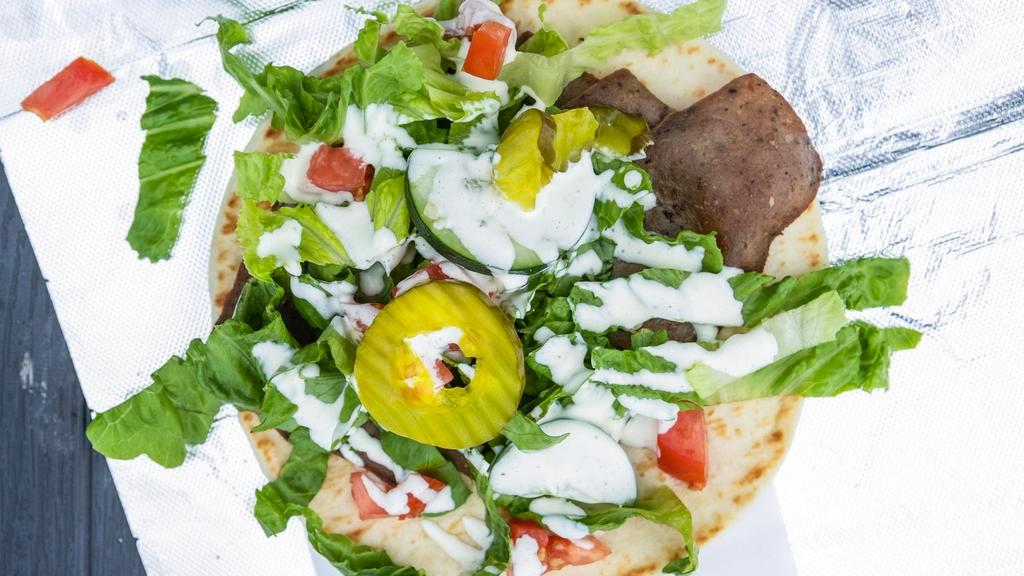 Gyro Wraps · lamb and beef thinly sliced and wapped in pita bread with pita  bread with lettuce , tomatoes, cucumber, pickles, and feta cheese served with signature red and whiite sauce