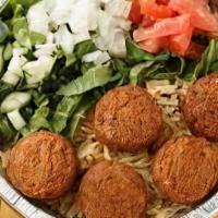 Falafel Over Rice · fried veggies balls made fresh to order over spiced basmati rice and salad served with signa...