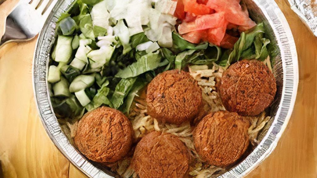 Falafel Over Rice · fried veggies balls made fresh to order over spiced basmati rice and salad served with signature red and white sauce