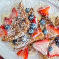Tres Leches French Toast · Two slices of brioche bread in tres leches mix. Topped with strawberries, blueberries, leche...