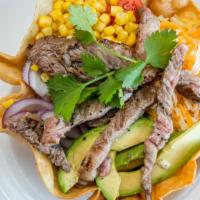 Ribeye Taco Salad · Corn mixed cheeses, avocado, black beans, red onions, tomato, and romaine lettuce, served in...