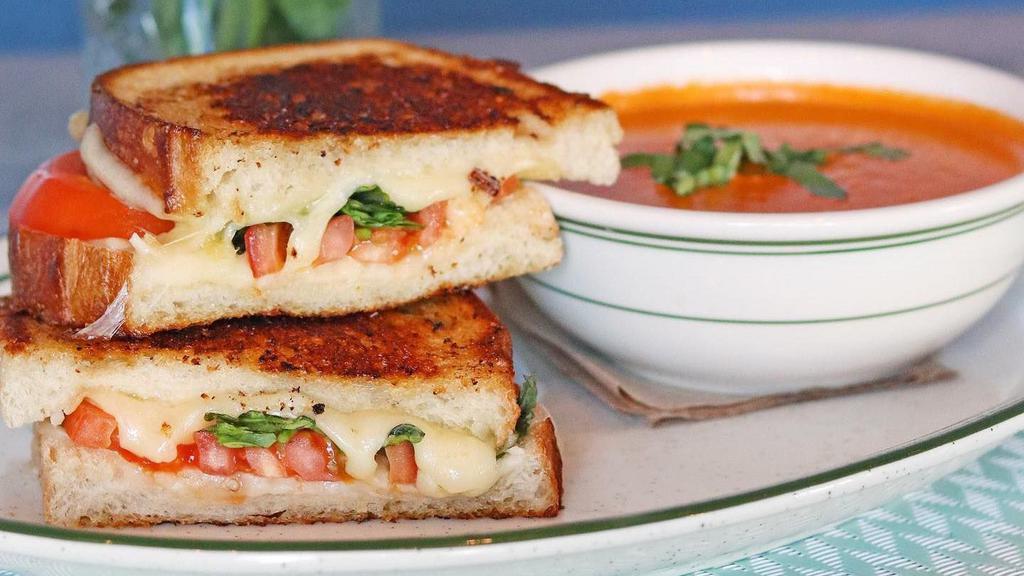 Homemade Tomato Basil Bisque 'N Tomato Basil Grilled Cheese Sam-Wich · Homemade bisque, grilled sourdough with Cheddar and mozzarella, fresh basil and sliced tomatoes.