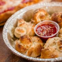 Garlic Knots (5 Pieces) · Five freshly baked knots tossed in fresh garlic, Parmesan cheese and butter. Served with mar...