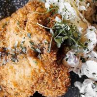 Schnitzel · Pork loin breaded and topped with black pepper gravy with German potato salad and sauerkraut.
