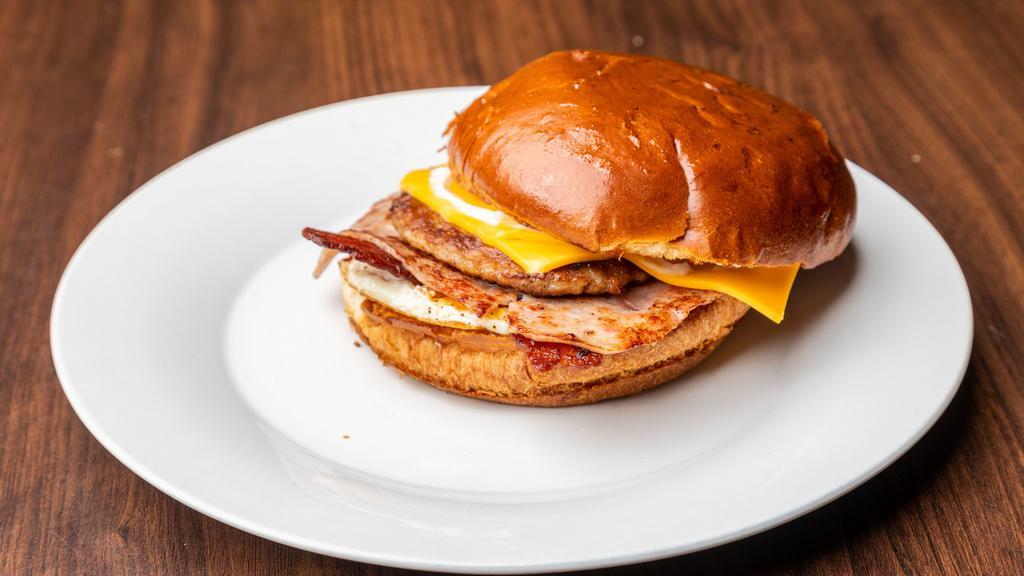 Loaded Breakfast Sandwich. · Fried egg, bacon, ham, sausage, cheese and mayo on toasted brioche bun.