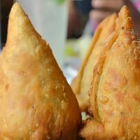 Samosa · Two fried pastry shells stuffed with roasted cumin potatoes and green peas served with mint ...