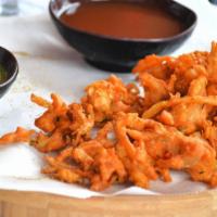Onion Pakora · Onions in a lightly seasoned lentil floured batter and deep fried.