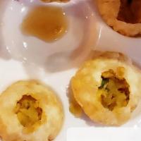 Pani Puri · A crispy wheat ball filled with potato and garbanzo beans poured in with some spicy tamarind...