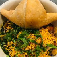 Samosa Chaat · Vegan. Vegan samosa topped with curried chickpeas, medley of chutneys, red onions and fresh ...