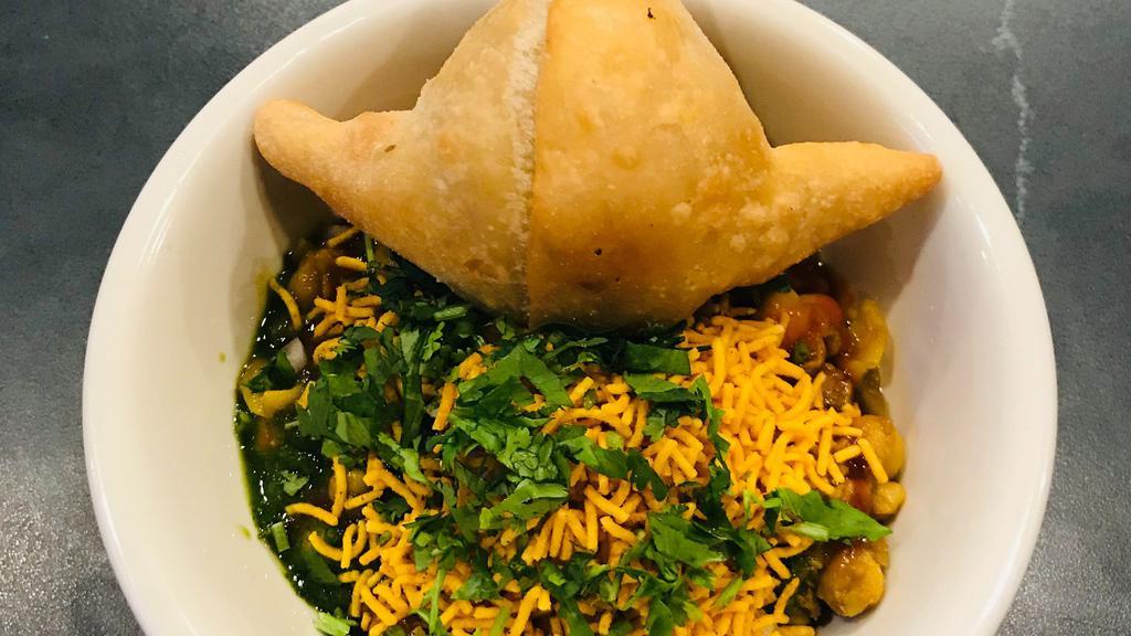 Samosa Chaat · Vegan. Vegan samosa topped with curried chickpeas, medley of chutneys, red onions and fresh cilantro.