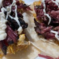 Brisket Tacos · Three tacos made with scrambled eggs, potato hash, and homemade smoked brisket.