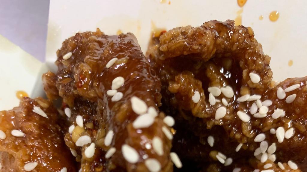 Sesame Chicken (Hot) · Spicy large pieces of battered chicken glazed with a sweet brown sauce.