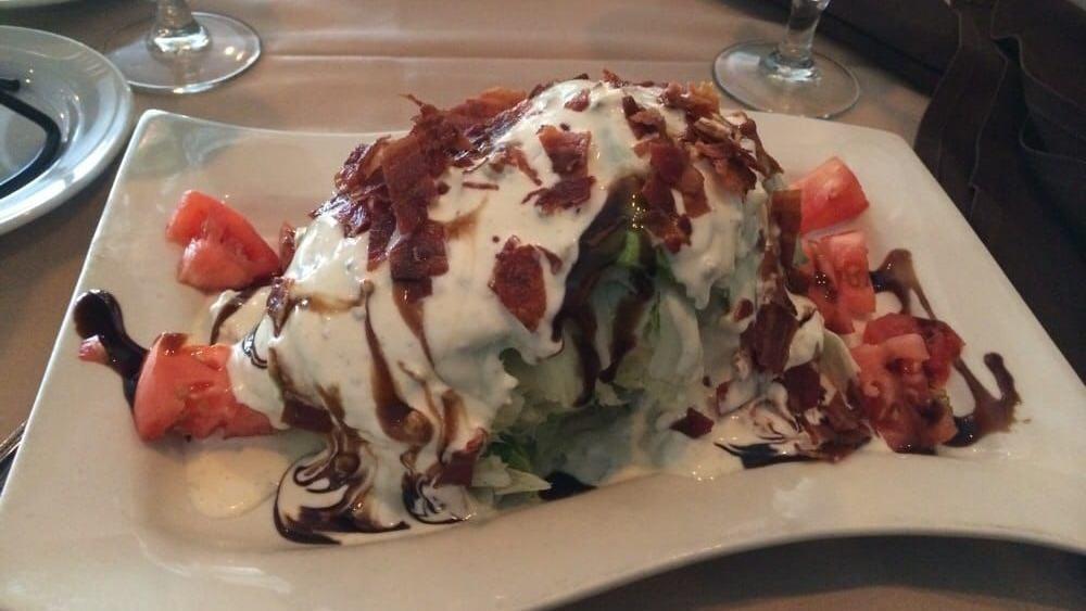 Wedge Salad · Iceberg lettuce, bacon, and chopped tomatoes with bleu cheese dressing and balsamic reduction.