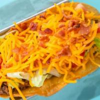 Texas Taco · Fresh seasoned ground beef topped with lettuce, tomato, sour cream, mixed cheese and bacon o...