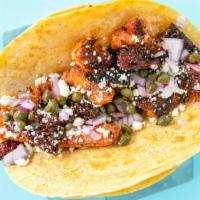 Spicy Salmon Taco · Grilled salmon fillet sautéed with sun dried tomatoes, sweet spices, garlic, red onions, cap...
