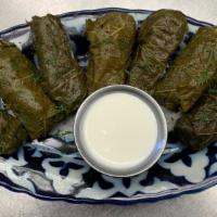 Dolma · Grape leaves stuffed with seasoned ground beef and rice, served with a mint sour yogurt sauce