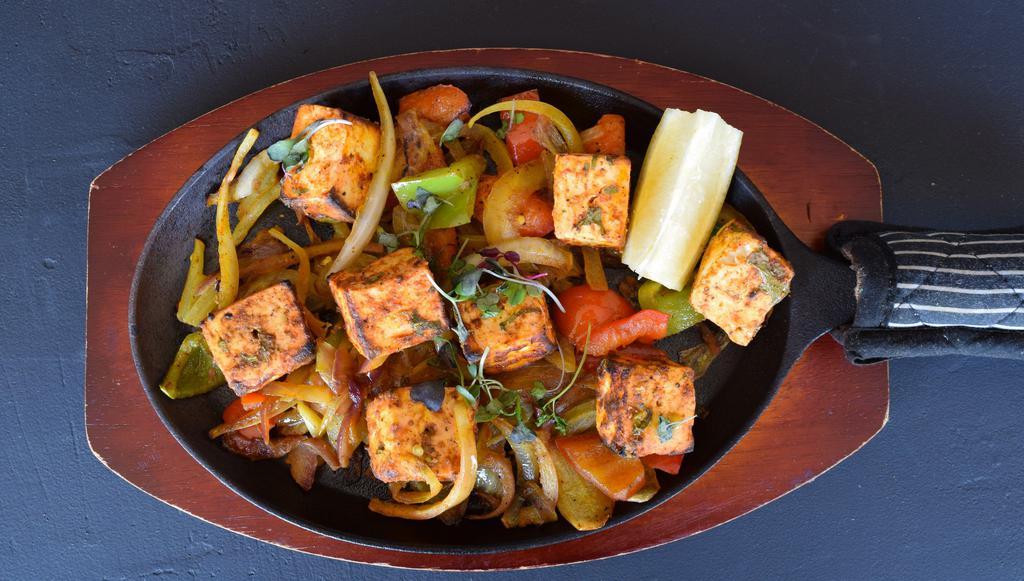 Paneer Tikka · Marinated in yogurt, ginger, garlic, tandoori spices, and served over onions and peppers