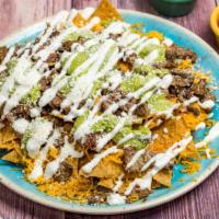 Carne Asada Chips Or Fries · Chips or fries topped with cheddar cheese, carne asada, guacamole, crema and cotija cheese.