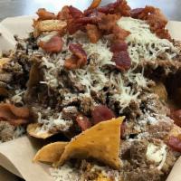 Triton Chips Or Fries · Chips or fries topped with carne asada, refried beans, bacon, Monterey jack, cheddar and cot...