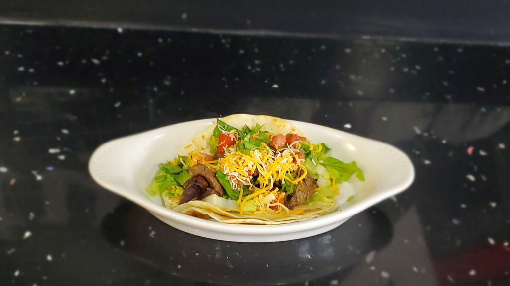 Steak Tacos · Served in a soft tortilla shell with lettuce, pico de gallo, and cheese.