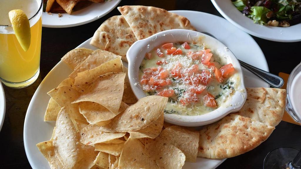 Spin Dip · Creamy blend of spinach, artichoke hearts, melted Parmesan and provolone cheese. Served with garlic naan and tortilla chips.