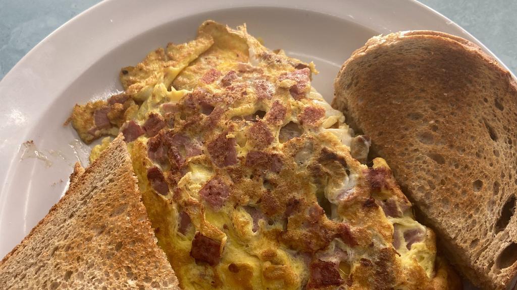 Wild Turkey Omelet · Turkey sausage, turkey bacon, and American cheese. Made with three eggs, served with your choice of home fries or grits and toast.