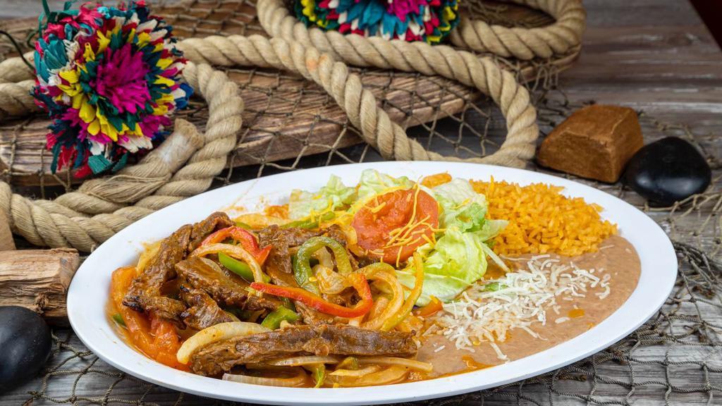 Fajitas De Res · Strips of grilled steak with onions and bell peppers. Served with rice, beans, green salad, and tortillas.