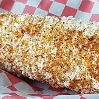 Elotes  · Seasoned corn. Corn topped with mayo, queso fresco, and pepper seasoning. In a bowl.  Cob av...