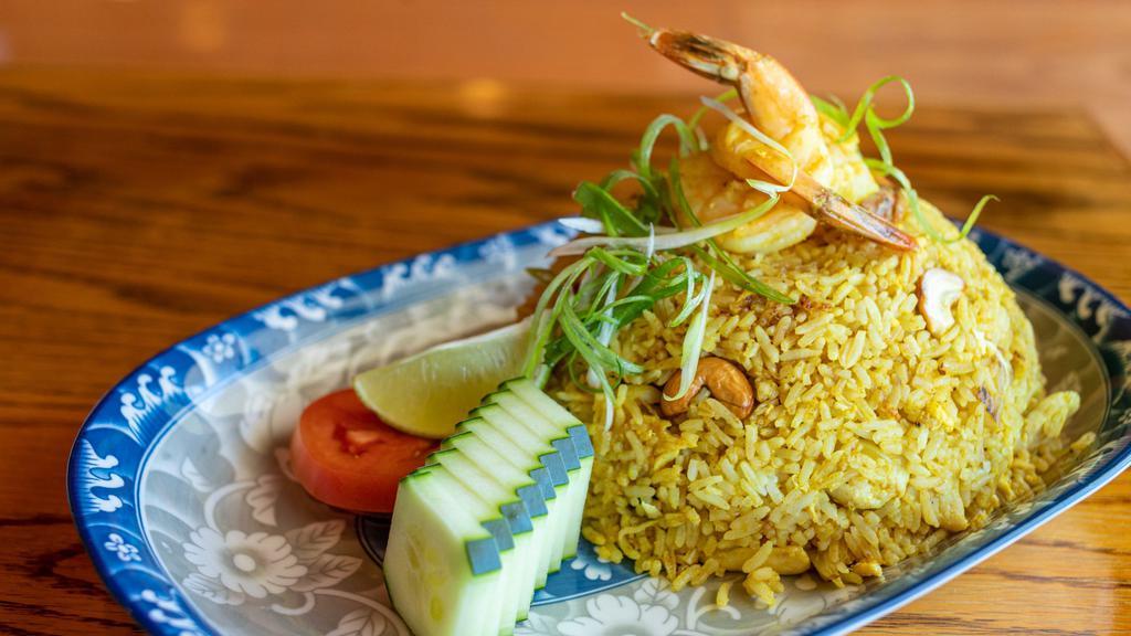 Pineapple Fried Rice · Gluten-free. A perfect combination of fried rice with shrimps, chicken, asian sausage, pineapples, golden raisins, cashew nuts, eggs, garlic, onions and curry powder.