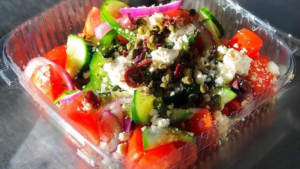 Greek Salad · Tomatoes, cucumbers, green peppers, red onions, capers, black olives, feta cheese, and extra virgin olive oil