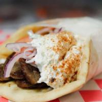 Gyro Wrap · Served in pita bread and topped with onions, tomatoes, our homemade tzatziki sauce, and Gree...